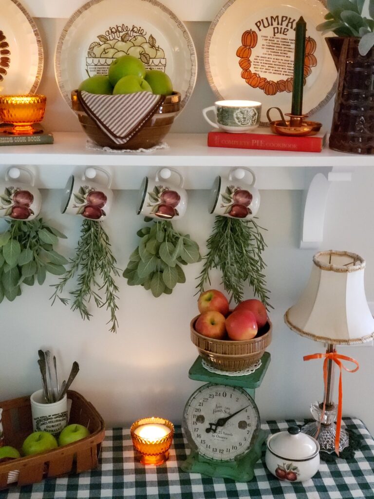 fall kitchen decor with herb bundles, apple mugs, bowl of apples and vintage scale