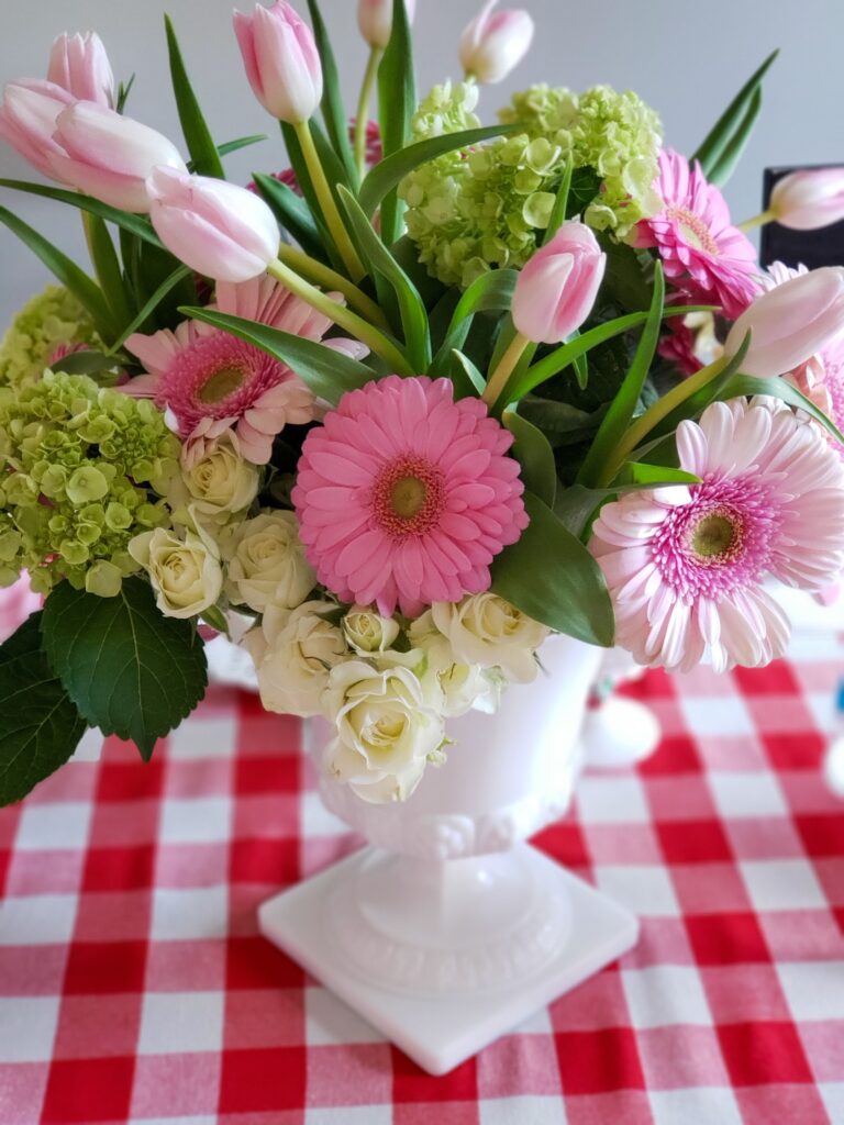 strawberry shortcake tablescape with a gingham tablecloth and flowers