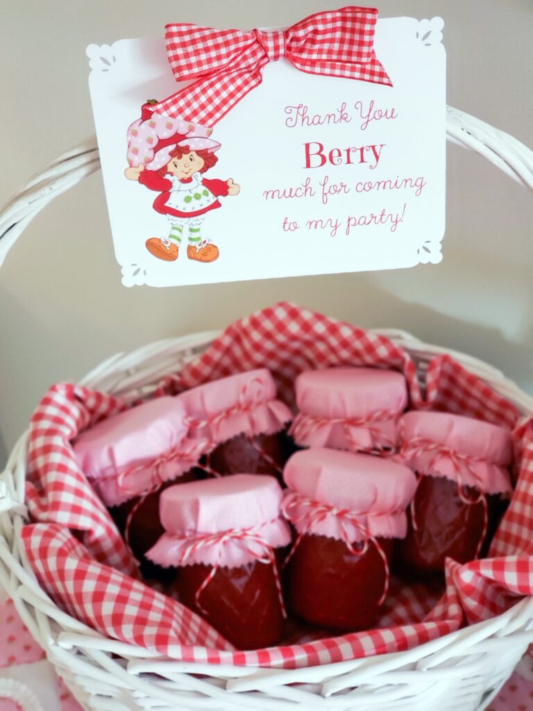 strawberry shortcake favor table with jam favors in a basket