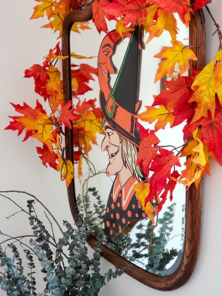 cozy cottage halloween decor with a witch die cut and fall leaves on a mirror