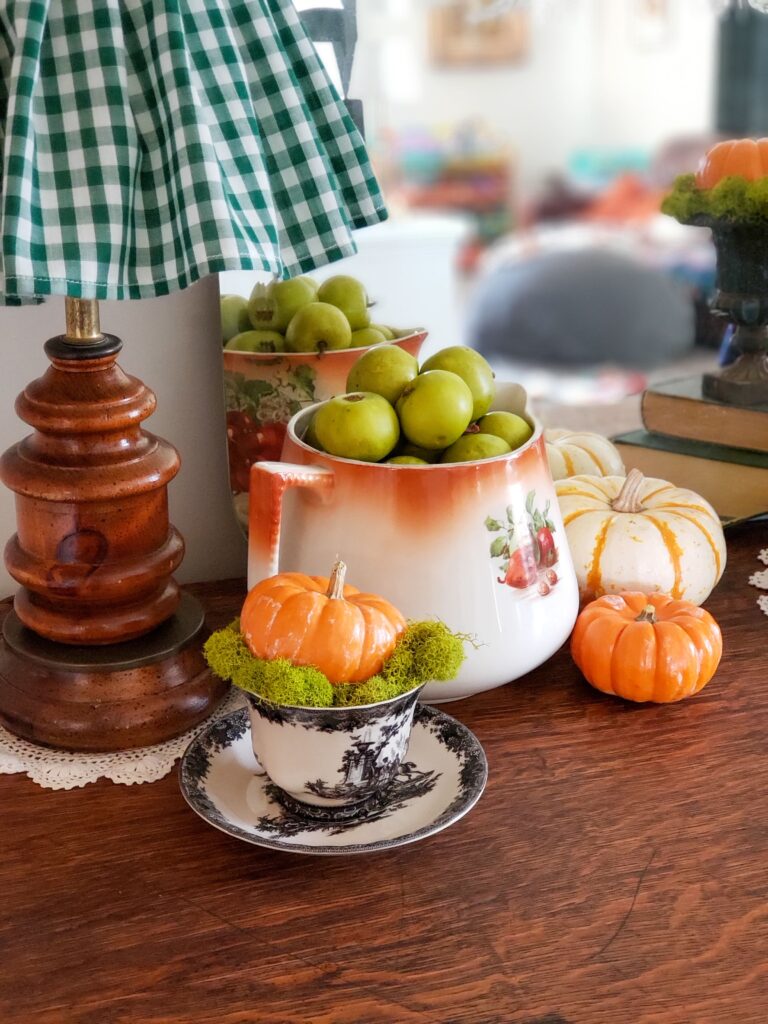 cozy cottage halloween decor with vintage pitcher, pumpkins and teacups