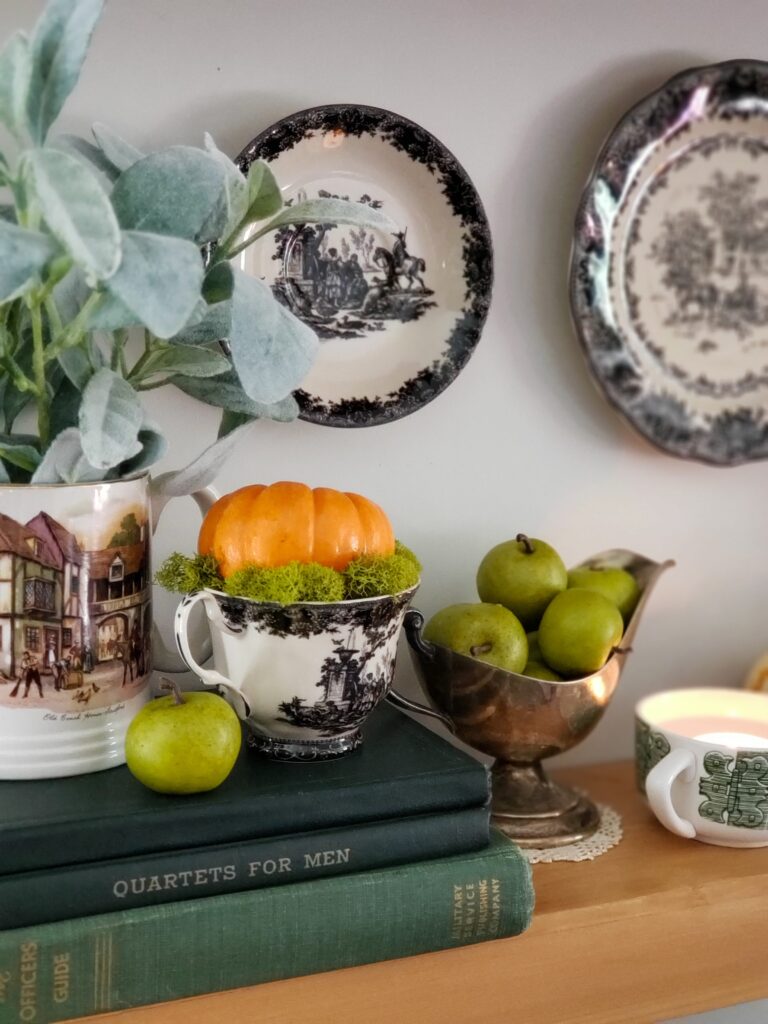 cozy cottage halloween decor with books, ducks in witch hats, pumpkins and teacups