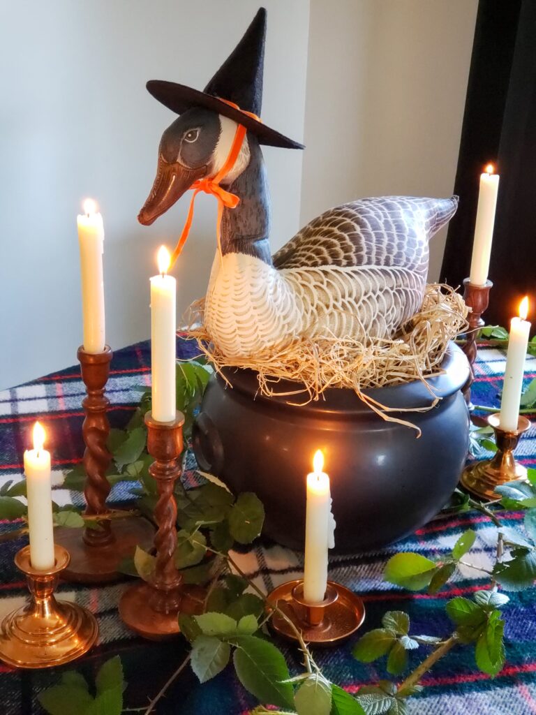 cozy cottage halloween decor with a goose sitting on a cauldron