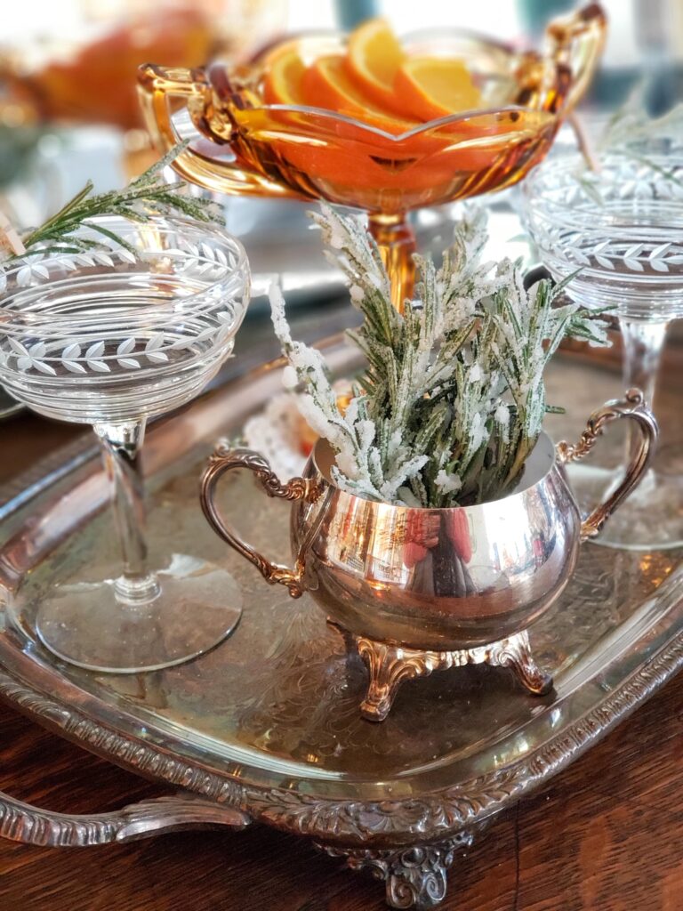 sugared rosemary in a silver dish with bourbon and cocktail accessories