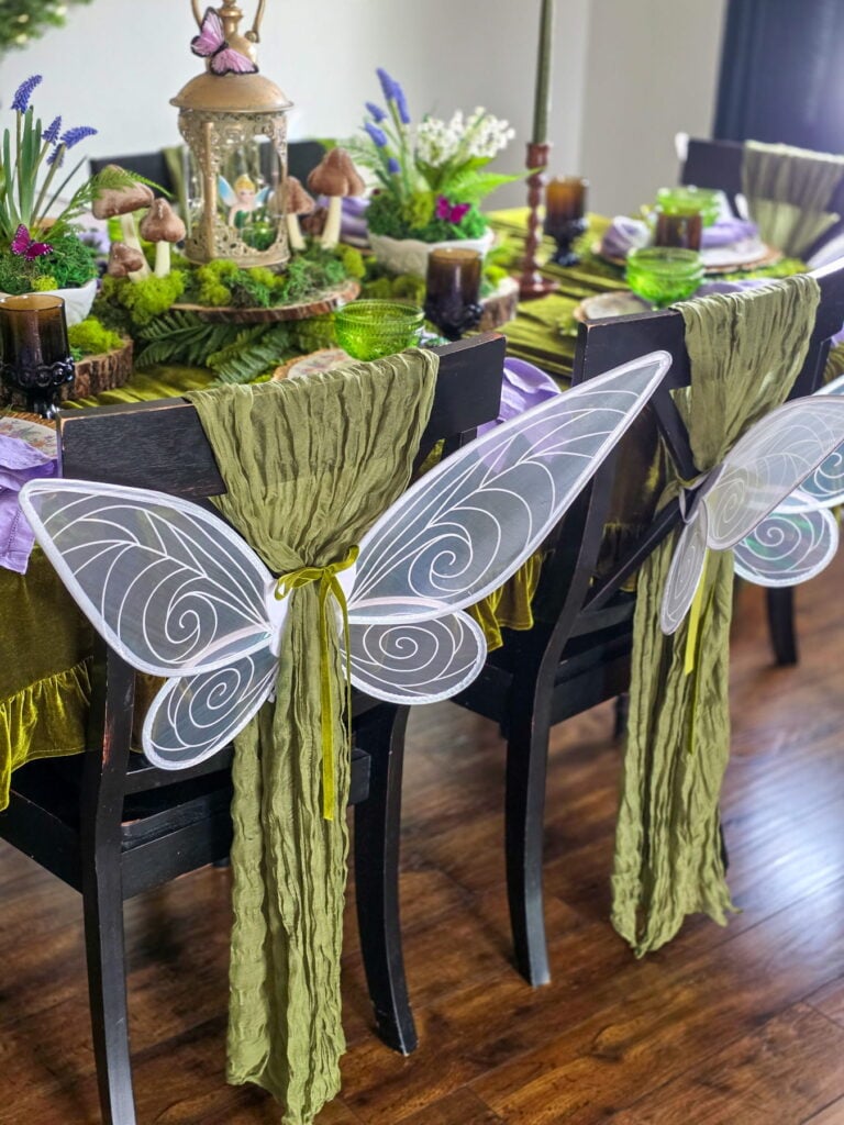 enchanted forest fairy party tablescape with fairy wings tied to chairs
