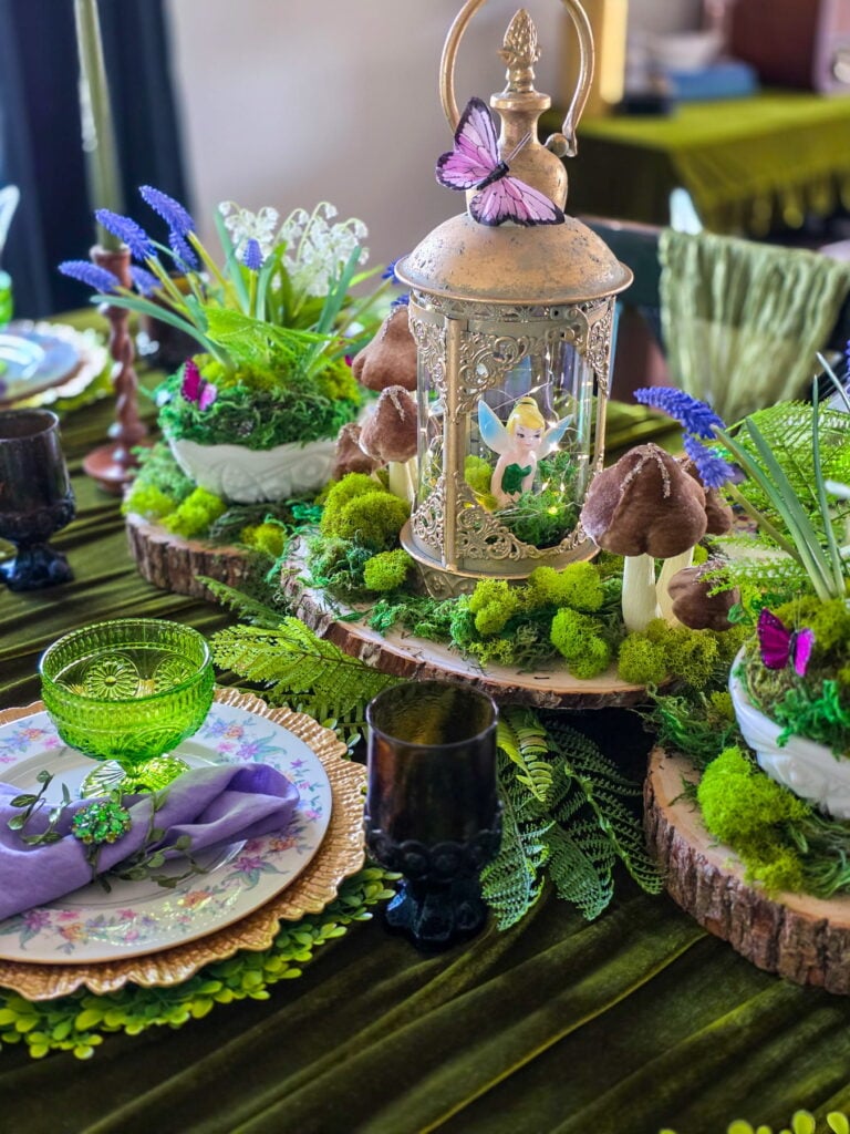 enchanted forest fairy party centerpiece with gold lantern, tinkerbell figurine, moss and mushrooms