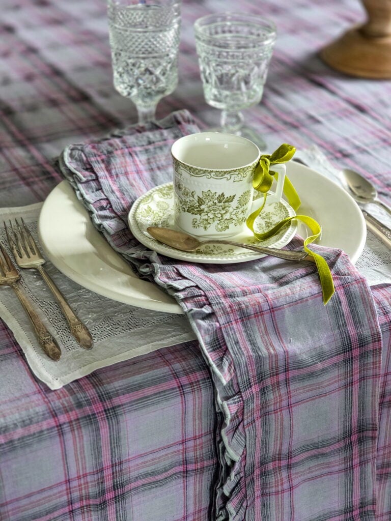 purple plaid tablecloth and napkin with white plate and green transferware teacup with green ribbon