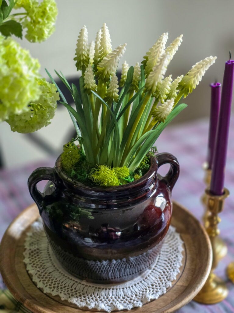 a vintage crock filled with faux flowers