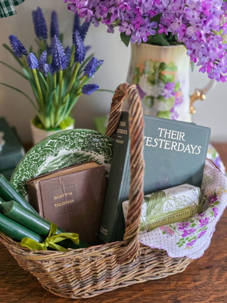 vintage basket filled with books, candles, soap and a plate
