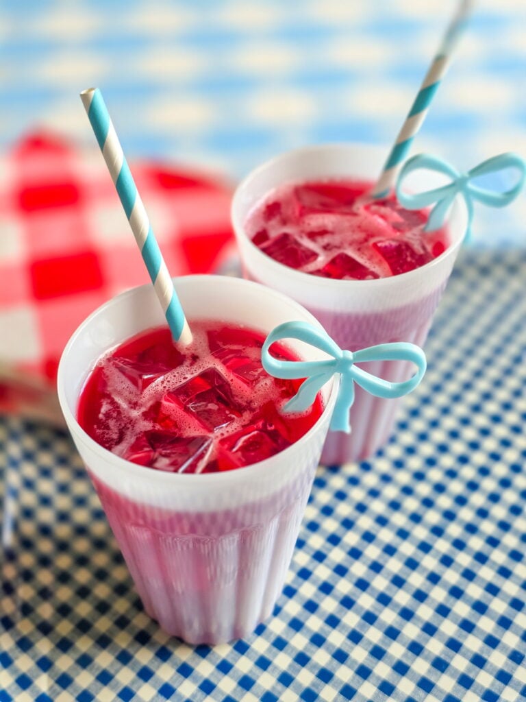 vintage red devil cocktail, the original cape codder in milk glass cup with gingham tray and striped paper straws