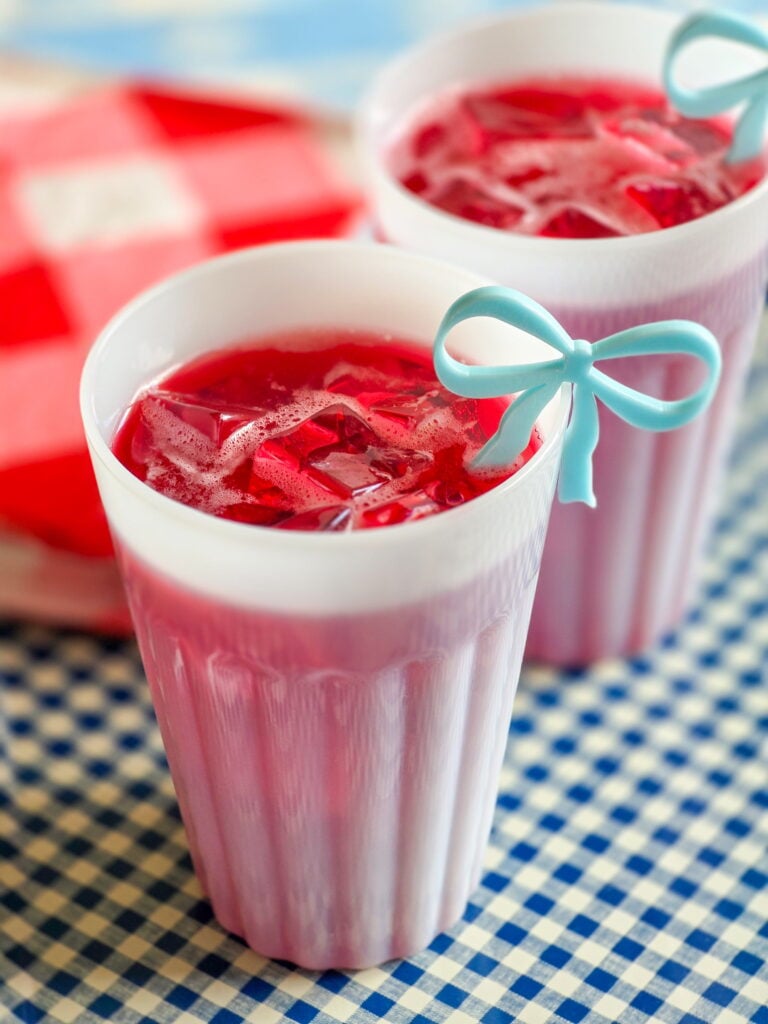 red devil cocktail-cape codder on gingham tray with red and white gingham napkins and blue bow drink charm