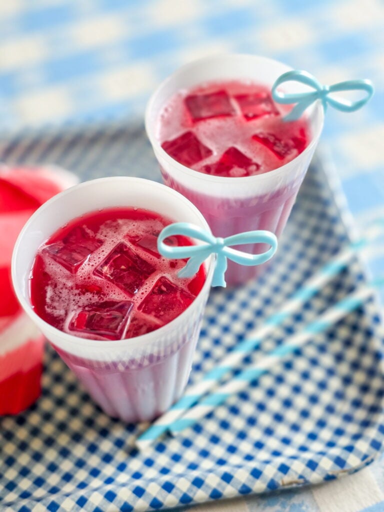 red devil cocktail-cape codder on gingham tray with red and white gingham napkins and blue bow drink charm