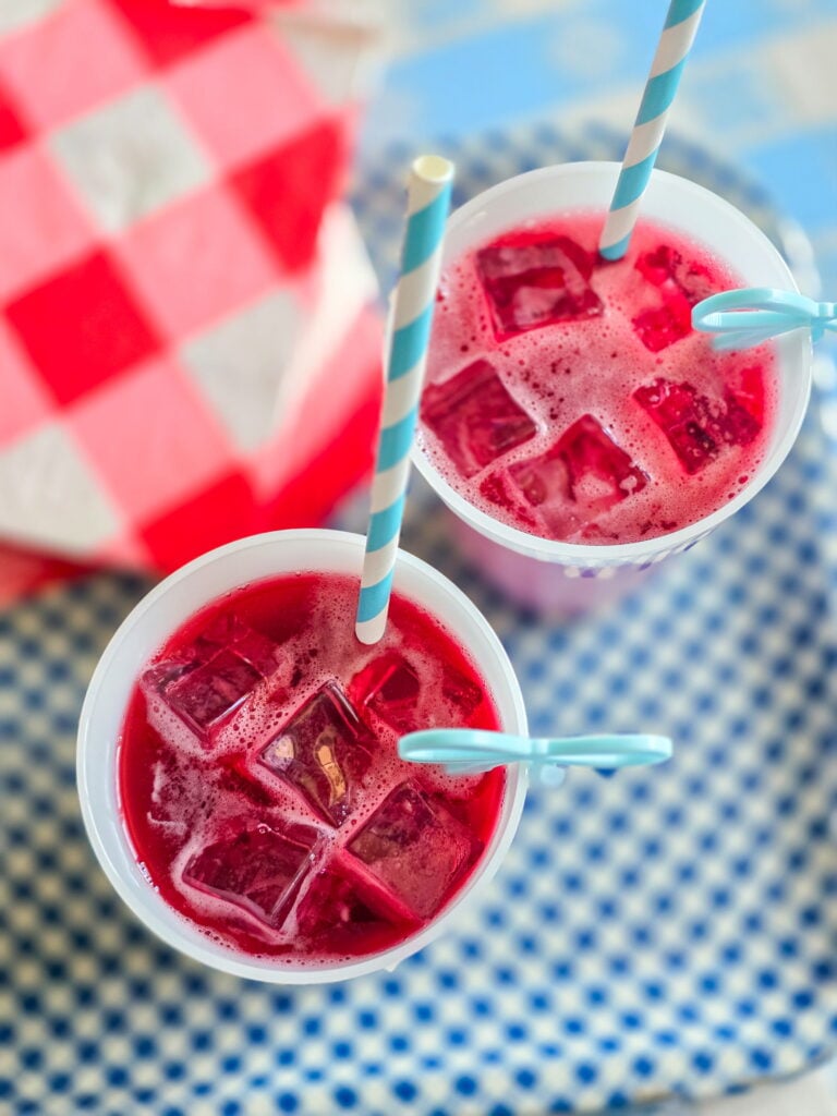red devil cocktail-cape codder on gingham tray with red and white gingham napkins and blue bow drink charm