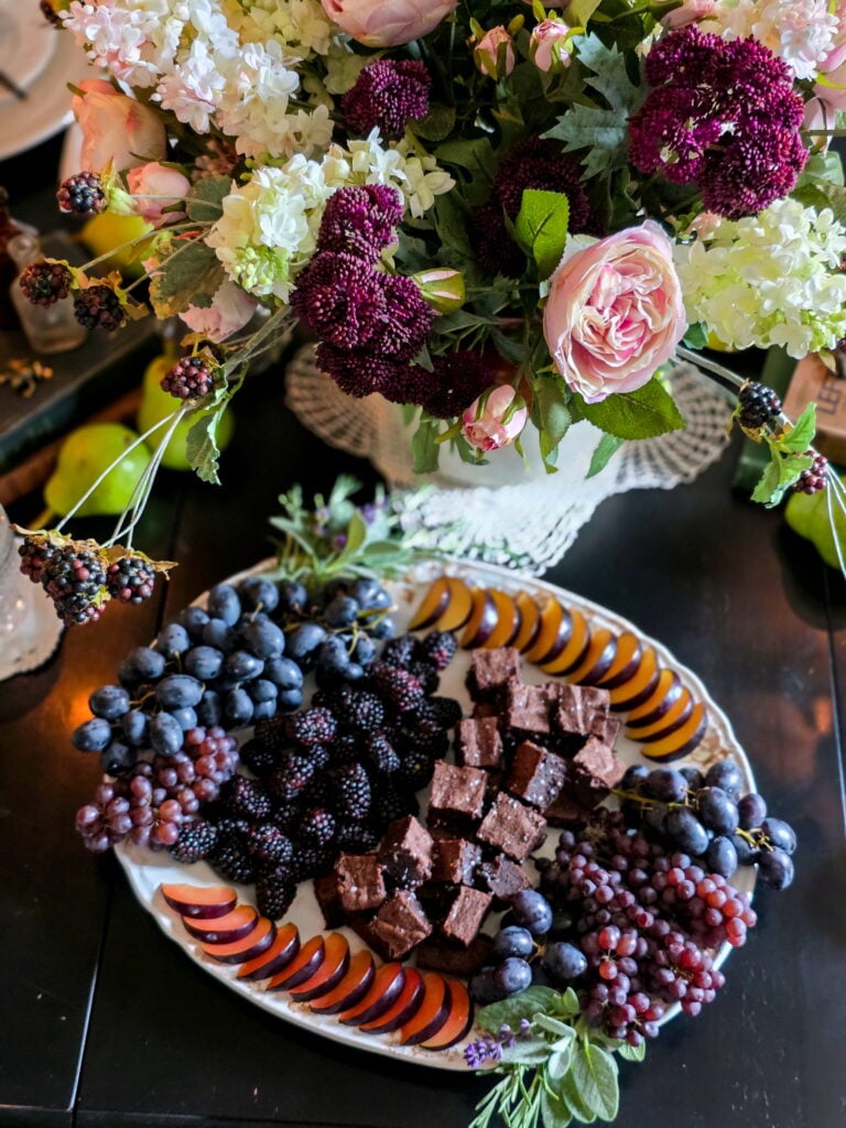 owens harvest fruit and dessert snack board with brownies and dark fruit on a vintage platter with flowers