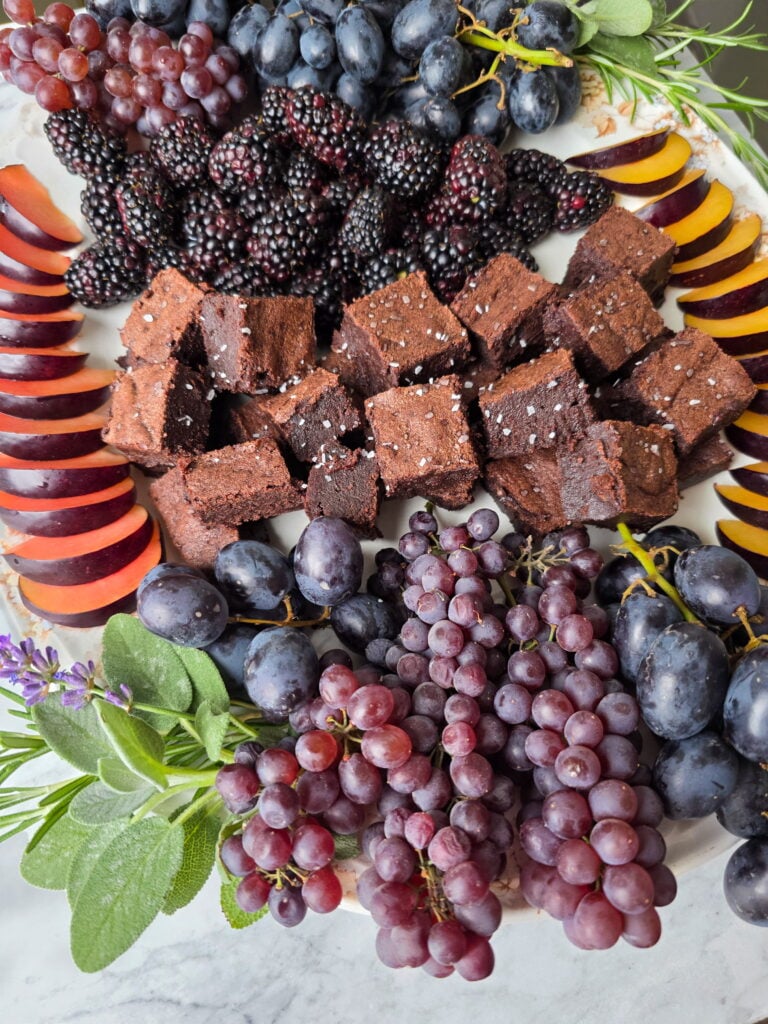 owens harvest fruit and dessert snack board with brownies and dark fruit and herbs