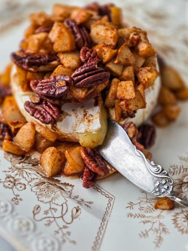 pear pecan baked brie on a vintage transferware platter with vintage knife