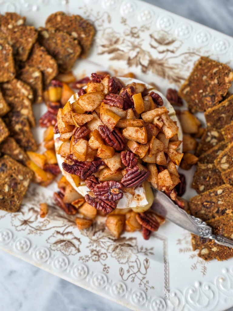 pear pecan baked brie on a vintage transferware platter with crackers